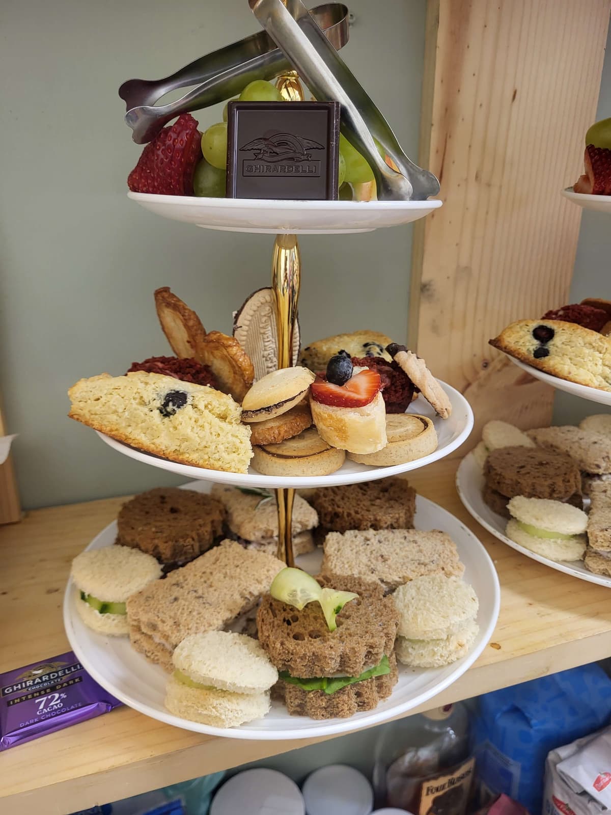 Three-tier afternoon tea spread with sandwiches and scones